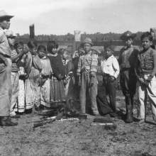  group of children standing around a fire in a corral. The children are identified from left to right as: Jack Micco, Howard Micco, Frances Tigertail, Rosie Billie, Agnes Johns, Louise Osceola, Pauline Jumper, Archie Johns, Joe Dan Osceola, Francis Osceola, and Stanford Jumper.