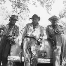  Charlie Micco, Tom Smith, and Dick Smith leaning agains the back of a car. Note the Florida Seminole Indian license plate on the vehicle. 